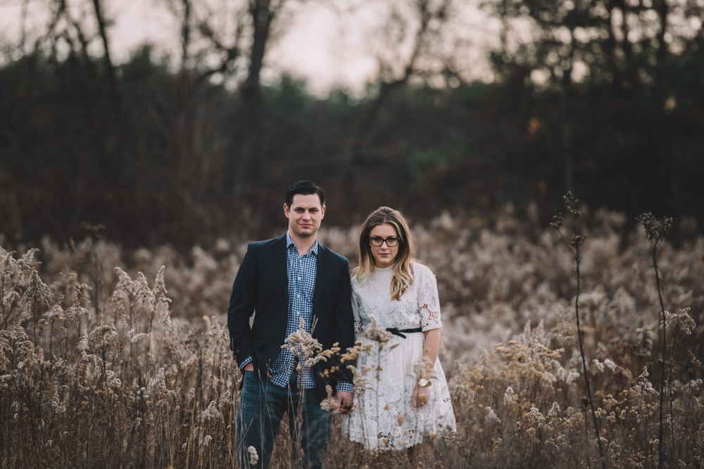 engaged couple standing in overgrown wildflowers in columbus