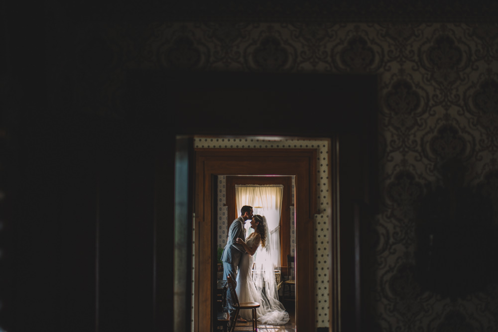couple sharing a quiet moment in a farmhouse on their wedding day