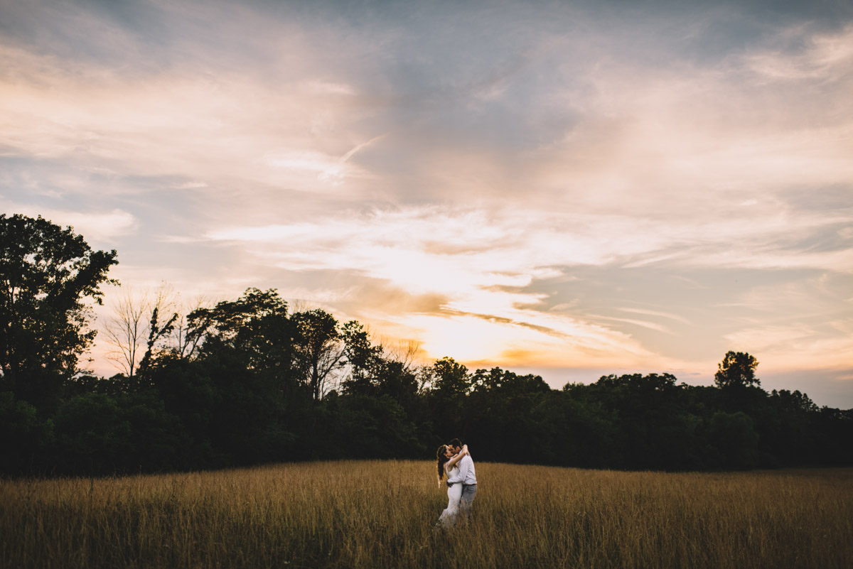 columbus ohio couple kissing in a field at sunset