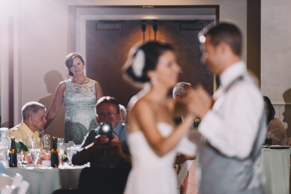 mom looking on at her daughter during her wedding first dance