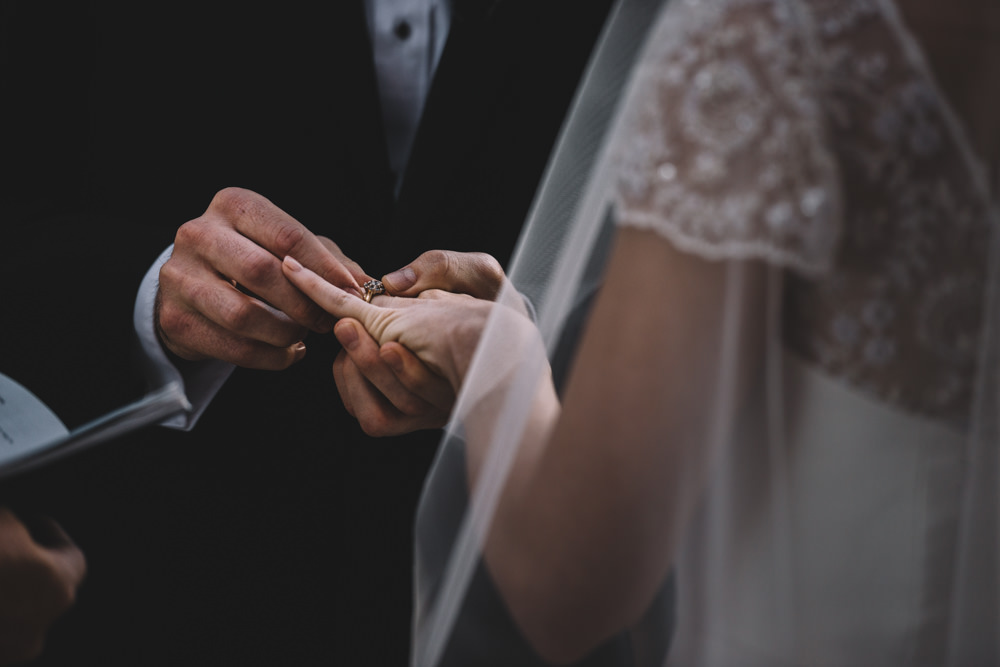 groom putting on bride's wedding ring at a via vecchia winery jewish wedding photography