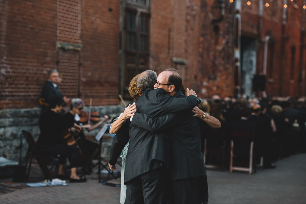 bride and groom's parents hugging each other after a via vecchia winery jewish wedding